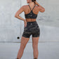 Person wearing a camouflage sports outfit standing against a concrete wall.