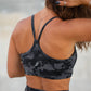 Person wearing a black camouflage sports bra and leggings set.