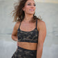 Woman wearing a camouflage sports bra and leggings against a neutral background